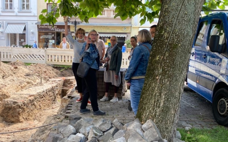 Mitglieder der Gemeinde besichtigen die archäologische Grabung.